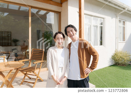 A couple standing in the garden of a lovely house 123772806