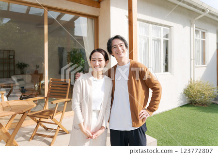 一對夫婦站在一棟漂亮房子的花園裡 一對夫婦站在一棟漂亮房子的花園裡 123772807