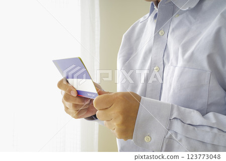 Middle-aged man looking at his savings passbook 123773048