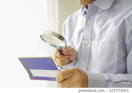 Middle-aged man looking at his savings passbook Middle-aged man looking at his savings passbook 123773051