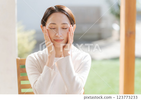 A woman in her 30s feels the moisture in her skin A woman in her 30s feels the moisture in her skin 123773233
