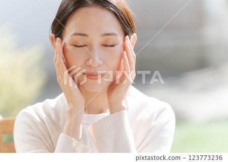 A woman in her 30s feels the moisture in her skin A woman in her 30s feels the moisture in her skin 123773236