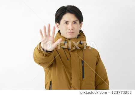 A man wearing a down jacket, posing in a restraining manner, white background 123773292