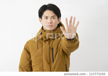 A man wearing a down jacket, posing in a restraining manner, white background 123773293
