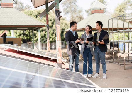 Sustainable business initiative. Professionals discussing solar energy solutions outdoors. Sustainable business initiative. Professionals discussing solar energy solutions outdoors. 123773989