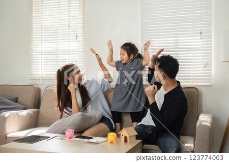 Family expressing joy while learning about savings and finances together 123774003