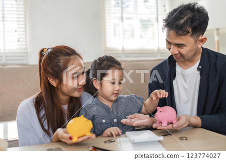 Engaged family discussing savings and budgeting with piggy banks at home. 123774027