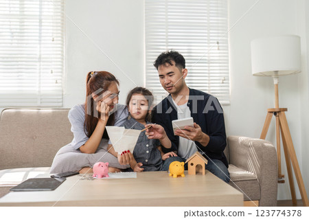 Family discussing financial strategies while involving their child in savings education. 123774378