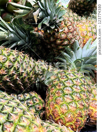 Fresh Pineapples in a Vibrant Market Display of Tropical Fruits, Colorful display of fresh, ripe pineapples at a market showcasing a tropical atmosphere Fresh Pineapples in a Vibrant Market Display of Tropical Fruits, Colorful display of fresh, ripe pineapples at a market showcasing a tropical atmosphere 123774380
