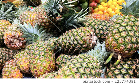 Fresh Pineapples in a Vibrant Market Display of Tropical Fruits, Colorful display of fresh, ripe pineapples at a market showcasing a tropical atmosphere Fresh Pineapples in a Vibrant Market Display of Tropical Fruits, Colorful display of fresh, ripe pineapples at a market showcasing a tropical atmosphere 123774381