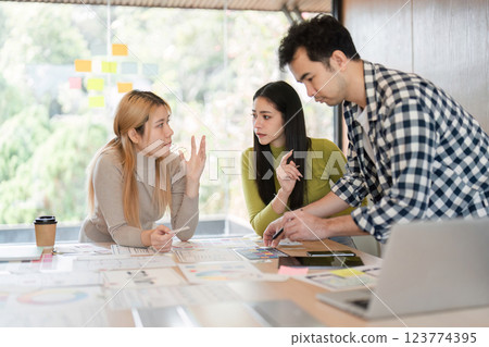 Diverse team members engaged in a design discussion and collaboration in an office. 123774395