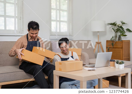 Two online sellers discussing packaging strategies at home, showcasing teamwork and collaboration. 123774426