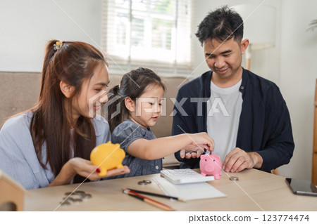 Family enjoying financial planning session with piggy banks and calculator. 123774474