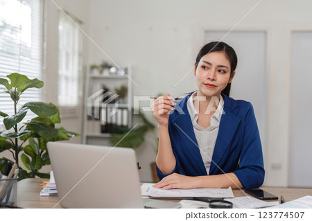 Contemplative businesswoman accountant considering financial strategies at her desk. 123774507