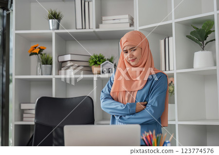 Diverse female accountant with a thoughtful expression reflecting on financial reports in an office. 123774576