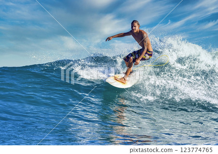 Male surfer on a blue wave 123774765