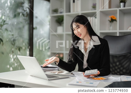 Cheerful businesswoman explaining financial concepts while working on a laptop. 123774930