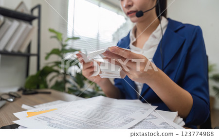 Accountant analyzing tax documents and financial paperwork in office 123774988