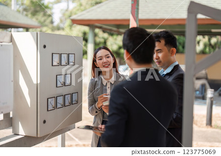 Dynamic sustainable strategy discussion. Diverse professionals collaborating on eco-friendly business practices in an outdoor setting. 123775069