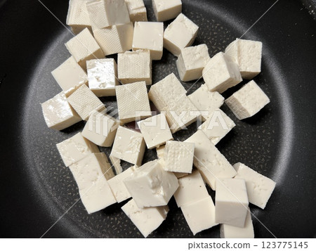 Diced firm tofu scattered in a frying pan 123775145