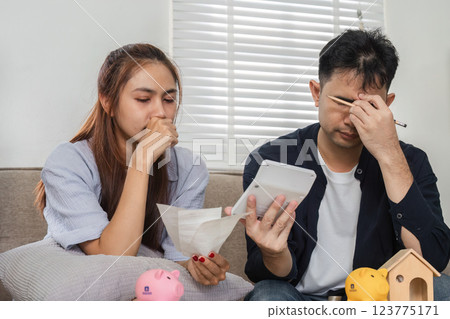 Concerned family reviewing bills and savings strategy together Concerned family reviewing bills and savings strategy together 123775171