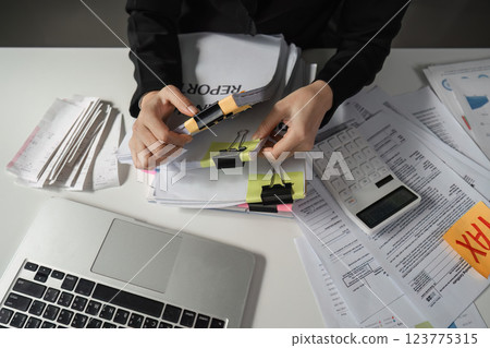 Accountant organizing financial paperwork with binder clips 123775315