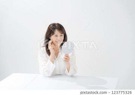 Smiling middle-aged woman holding a hand mirror 123775326