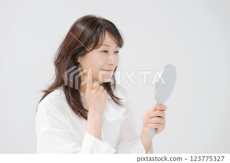 Smiling middle-aged woman holding a hand mirror 123775327