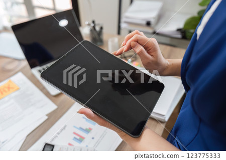 Accountant reviewing financial data on tablet in modern office 123775333