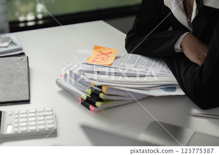 Tax documents and calculator on a desk, highlighting financial responsibilities. 123775387