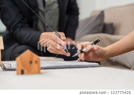Real Estate Planning. Individuals negotiating terms of property agreement with documents on the table. Real Estate Planning. Individuals negotiating terms of property agreement with documents on the table. 123775420