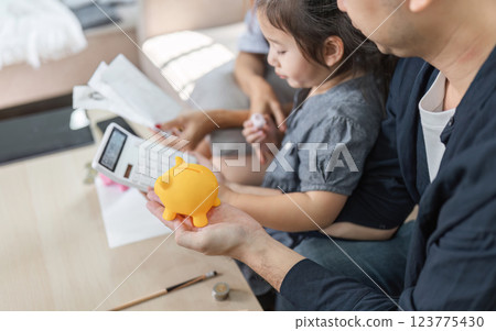 Family member holding a piggy bank, emphasizing savings and financial planning. 123775430