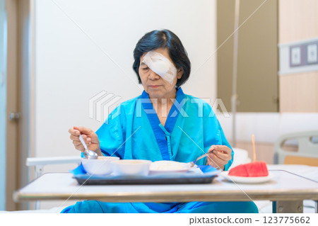 Senior Woman eating food after eye surgery in hospital . Eye disease, Cataract, Glaucoma, Age Related Macular Degeneration, Diabetic Retinopathy, Lasik, World Glaucoma day and health treatment Senior Woman eating food after eye surgery in hospital . Eye disease, Cataract, Glaucoma, Age Related Macular Degeneration, Diabetic Retinopathy, Lasik, World Glaucoma day and health treatment 123775662