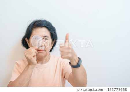 Elderly Woman with eye protective shield after eye surgery. Eye disease, Cataract, Glaucoma, Age Related Macular Degeneration, Diabetic Retinopathy, Vitreous, Lasik, World Glaucoma day and health Elderly Woman with eye protective shield after eye surgery. Eye disease, Cataract, Glaucoma, Age Related Macular Degeneration, Diabetic Retinopathy, Vitreous, Lasik, World Glaucoma day and health 123775668