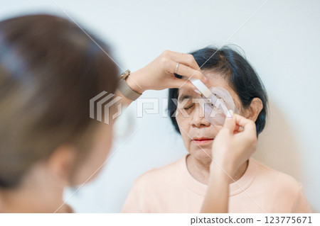 Senior Woman during eye protecting by shield after eye surgery. Eye disease, Cataract, Glaucoma, Age Related Macular Degeneration, Diabetic Retinopathy, Vitreous, Lasik, World Glaucoma day and health Senior Woman during eye protecting by shield after eye surgery. Eye disease, Cataract, Glaucoma, Age Related Macular Degeneration, Diabetic Retinopathy, Vitreous, Lasik, World Glaucoma day and health 123775671