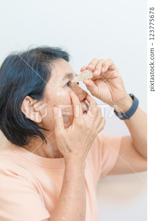 Elderly Woman use ophthalmic solutions or Eye Drops after eye surgery. Eye disease, Cataract,  Glaucoma, Age Related Macular Degeneration, Diabetic Retinopathy, World Glaucoma day and health treatment 123775678