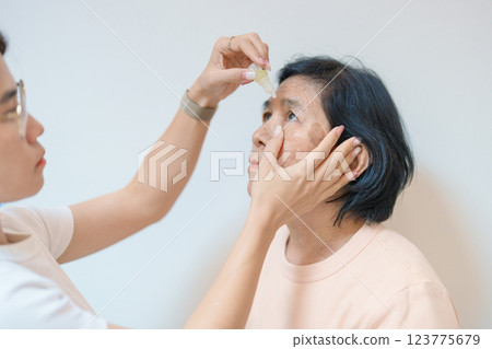 Elderly Woman use ophthalmic solutions or Eye Drops after eye surgery. Eye disease, Cataract, Glaucoma, Age Related Macular Degeneration, Diabetic Retinopathy, World Glaucoma day and health treatment Elderly Woman use ophthalmic solutions or Eye Drops after eye surgery. Eye disease, Cataract, Glaucoma, Age Related Macular Degeneration, Diabetic Retinopathy, World Glaucoma day and health treatment 123775679