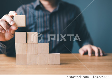hand of a businessman stacking wood empty ten blocks with copy space for text or symbols, development concept for growth success process. hand of a businessman stacking wood empty ten blocks with copy space for text or symbols, development concept for growth success process. 123775688