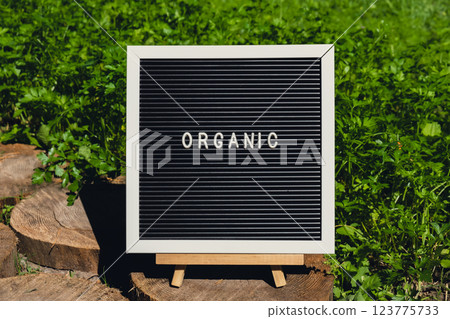 Letter board with text ORGANIC on background of garden bed with green herb parsley. Organic farming, produce local vegetables concept. Supporting local farmers Letter board with text ORGANIC on background of garden bed with green herb parsley. Organic farming, produce local vegetables concept. Supporting local farmers 123775733