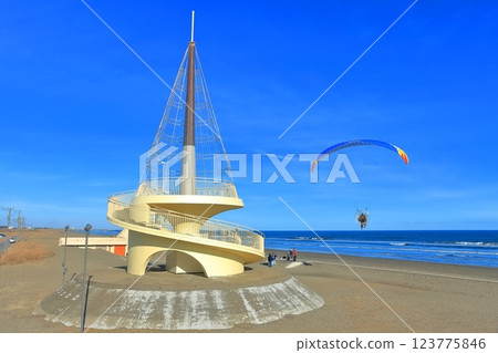 [Chiba] Kujukuri Beach Tower and motor paraglider under sunny weather 123775846