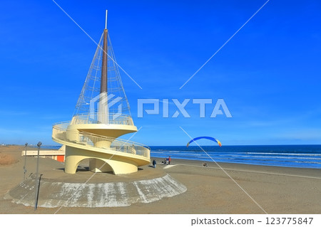 [Chiba] Kujukuri Beach Tower and motor paraglider under sunny weather 123775847