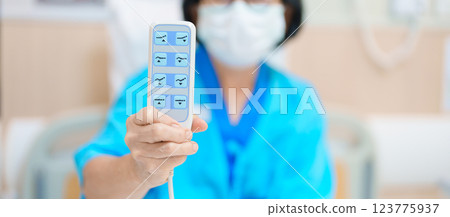 Elderly asian Woman patient hand using remote control for adjust level bed in hospital room. Happy Senior illness resting on comfortable electric bed in modern hospital Elderly asian Woman patient hand using remote control for adjust level bed in hospital room. Happy Senior illness resting on comfortable electric bed in modern hospital 123775937