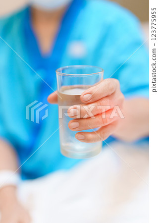 Senior woman with Tremor hand during taking glass of water in hospital. Parkinson disease April awareness month, Carpal Tunnel Syndrome, rheumatoid and brain injury and Neurological disorder concept 123775955
