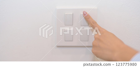 Female finger pushing for turn on light switch on white wall at home room. Woman hand turn off lighting Switch. Energy Saving, energy power control, electrical, eco environment, and lifestyle concept Female finger pushing for turn on light switch on white wall at home room. Woman hand turn off lighting Switch. Energy Saving, energy power control, electrical, eco environment, and lifestyle concept 123775980