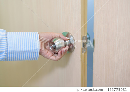 Woman hand holding doorknob and Open door. close the door knob 123775981