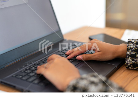 Female hands working on laptop keyboard in office. fingers type at keys, close-up background blurred workspace Female hands working on laptop keyboard in office. fingers type at keys, close-up background blurred workspace 123776141