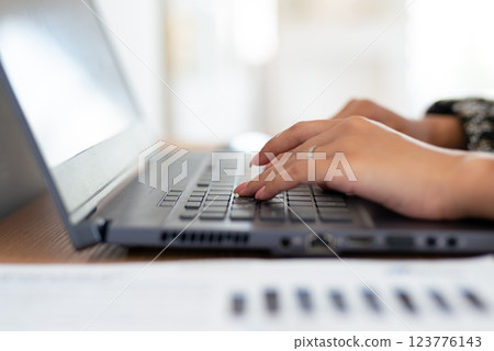 Woman hands works on laptop fingers typing on keyboard she focused on work or browsing online content. Woman hands works on laptop fingers typing on keyboard she focused on work or browsing online content. 123776143