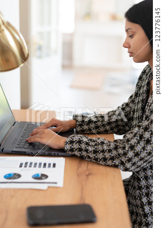 Freelance woman typing at laptop and working from home office. Freelance woman typing at laptop and working from home office. 123776145