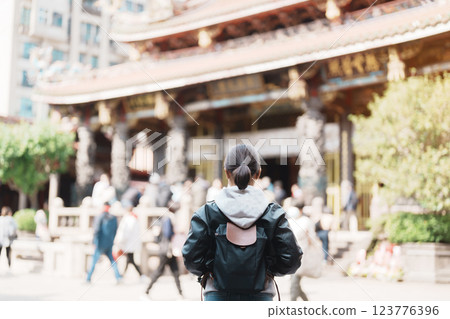woman traveler visiting in Taiwan, female Tourist sightseeing at Longshan Temple, Chinese folk religious temple in Wanhua District, Taipei City. landmark and popular. Travel and Vacation concept 123776396