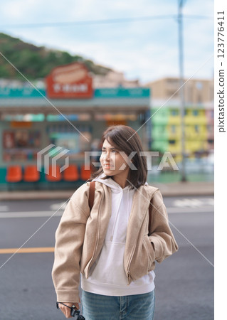 woman traveler visiting in Taiwan, female Tourist with backpack sightseeing at Keelung, Colorful Zhengbin Fishing Port. Popular landmarks and attractions near Taipei City.  Asia Travel concept 123776411